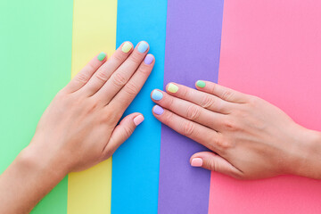 Female hands with bright summer color nails on a colorful background