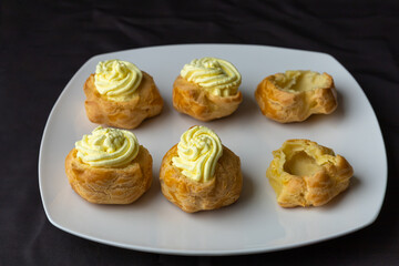Filled and unfilled puff pastries on a plate.