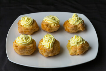 Filled vanilla creme custard pastries displayed on a white dish.