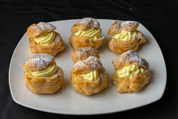 homemade creme puff custard pastries topped with powdered sugar