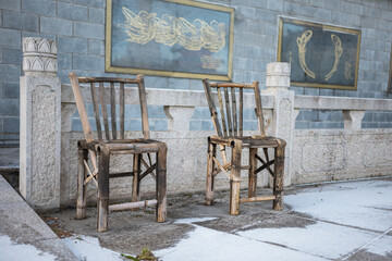 Two bamboo chairs at the entrance of the dragon gate at wintertime