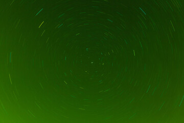 Background of round or circular star track or trajectory on the green clear night sky. Symbol of...