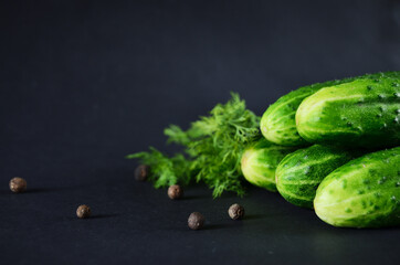 a bunch of green and ripe on a black background with dill and pepper