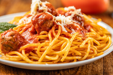 spaghetti dinner with meatballs and tomato sauce  arranged in a wooden background.