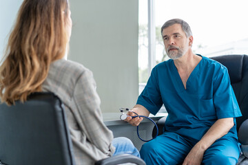 Senior surgeon consults young woman, doctor with patient in medical office.