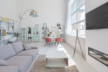 Cozy luxury modern interior design of a studio apartment in extra white colors with fashionable expensive furniture in a minimalist style. white tiled floor, kitchen, relaxation area and workplace