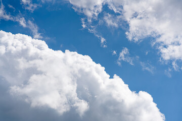 Naklejka na ściany i meble puffy white clouds on a blue sky divided diagonnally
