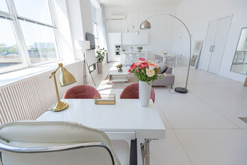 Cozy luxury modern interior design of a studio apartment in extra white colors with fashionable expensive furniture in a minimalist style. white tiled floor, kitchen, relaxation area and workplace