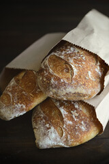 Slices of bread. Baked bread of sourdough. Artisan bread on dark background. The bread of sourdough, homemade and natural creation. The sourdough has natural yeast, which makes the food healthier, as 