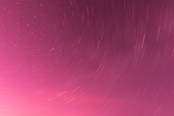 Background of round or circular star track or trajectory on the red, pink or rose clear night sky....