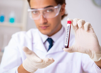 Young handsome lab assistant testing blood samples in hospital