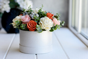 Bouquet of beautiful bright rose flowers in a gift cylindrical cardboard box