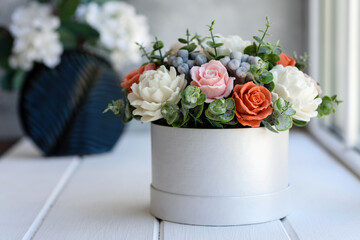 Bouquet of beautiful bright rose flowers in a gift cylindrical cardboard box
