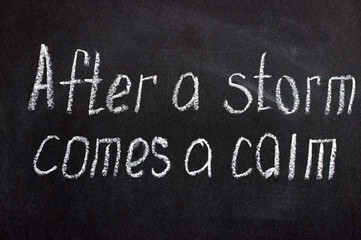 
The inscription on the dark board "after the storm comes calm". Motivating phrase