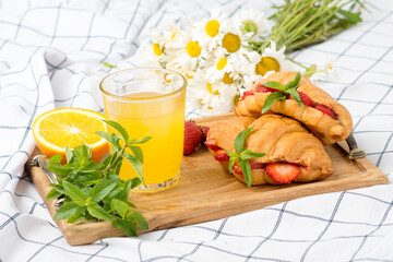 croissants with strawberries and orange juice, vegetarian breakfast in bed, French breakfast