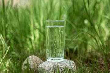 Glass of clear water on a green background. The concept of natural products, no preservatives. Copy space.