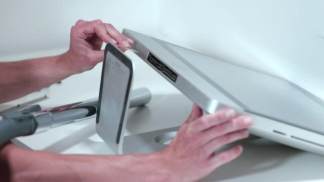 The man in the service cleans the ventilation holes of the PC case. Vacuuming particles and dirt. Computer performance boost.