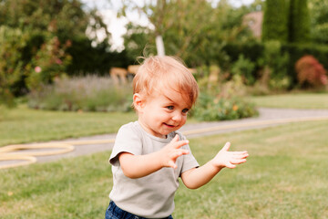 Close-up of baby girl clapping hands in garden