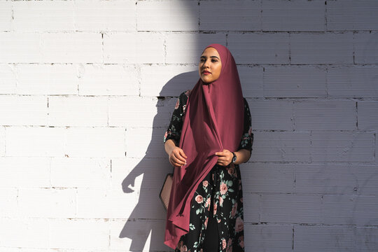 Beautiful Muslim Girl Wearing Hiyab Over a White Wall Outdoors. Lifestyle Concept.