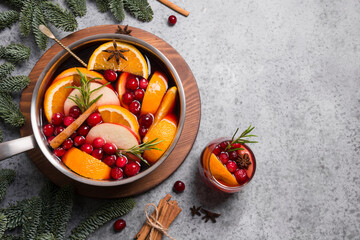 Mulled wine in with cardamom and star anise on black table with fir tree branches.
