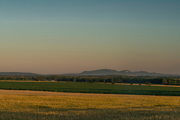 In middle of dry field in sunset color evening near Melcany village with moon