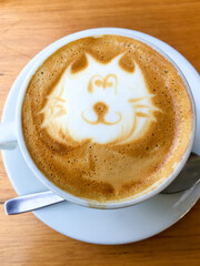 top view of a cup of capuccino with a cat draw made from milk foam