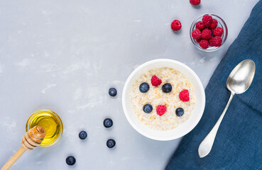 Oatmeal with berries and honey on dark blue napkin