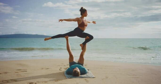 Incredible acro yoga couple at a sandy beach, fitness and healthy lifestyle goals