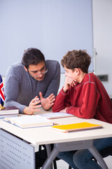 Young male teacher and schoolboy in the classroom