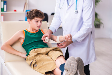 Fototapeta premium Sick boy visiting young male doctor pediatrician