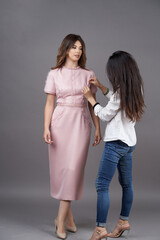 Woman fashion designer measuring dress on fashion model girl