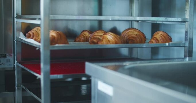 Confectionery workshop, the manufacture of bakery products. On the shelves are a freshly prepared portion of croissants for sale.
