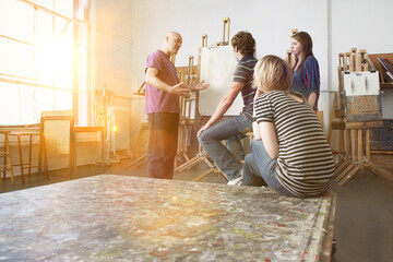 Artist talking to young artists in studio