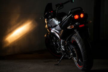 Naklejka na ściany i meble Sports black motorcycle on a background of an underground gray wall in the studio.