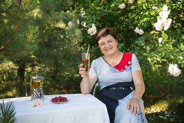 Picture of a middle-aged woman. Concept of emotions. Woman is happy to have rest outdoors after...