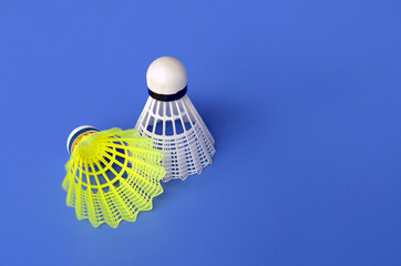 Yellow and white badminton shuttlecocks on a blue background with copy space.