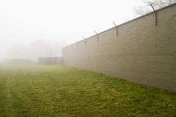 Fototapeta na wymiar Brick wall surrounding field