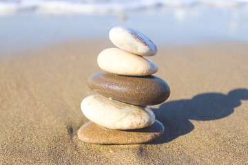 Fototapeta na wymiar zen stones on the beach. Concept of harmony, stability, and meditation.