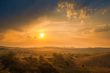 Naklejka na ściany i meble Magnificent summer sunset over Tuscany fields and hills