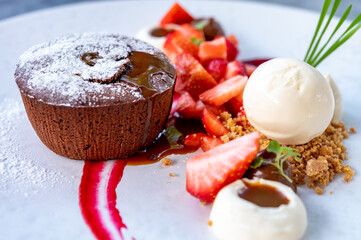 Tasty dessert, hot chocolate cake and vanilla ice cream with fresh strawberry