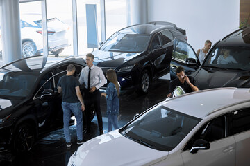 Car rentals retail sales top view selective focus of a sales agent talking to customers in a car dealership buyers choosing a car
