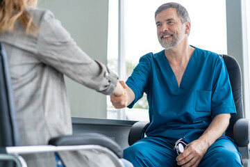 Obraz premium Doctor shaking hands to patient in the office at desk.