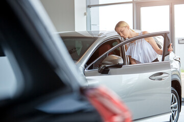 Selective focus of a young girl choosing a car at a dealership