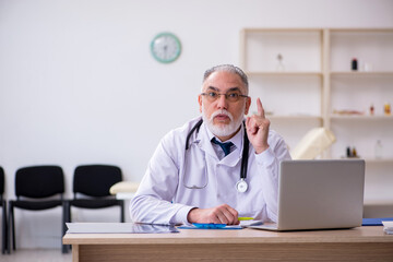 Old male doctor working in the clinic