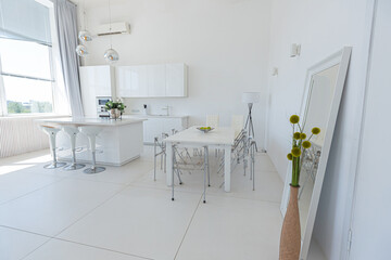 Cozy luxury modern interior design of a studio apartment in extra white colors with fashionable expensive furniture in a minimalist style. white tiled floor, kitchen, relaxation area and workplace