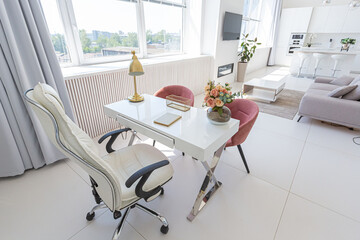 Cozy luxury modern interior design of a studio apartment in extra white colors with fashionable expensive furniture in a minimalist style. white tiled floor, kitchen, relaxation area and workplace