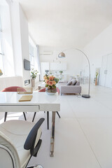 Cozy luxury modern interior design of a studio apartment in extra white colors with fashionable expensive furniture in a minimalist style. white tiled floor, kitchen, relaxation area and workplace