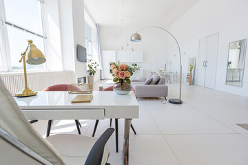 Cozy luxury modern interior design of a studio apartment in extra white colors with fashionable expensive furniture in a minimalist style. white tiled floor, kitchen, relaxation area and workplace