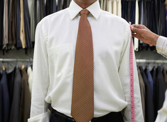 Tailor measuring business man for suit