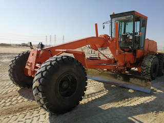 Grader is working on road construction. Using for an equal plain leveling road. A heavy-duty machine is working on site. 